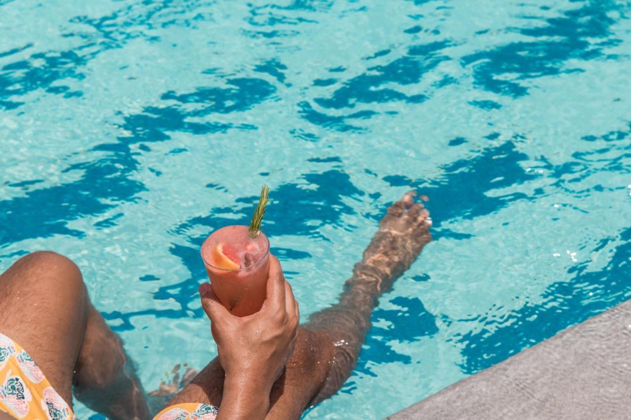 Jeddah Marriott Hotel Madinah Road Bagian luar foto A woman holding a cocktail in a swimming pool